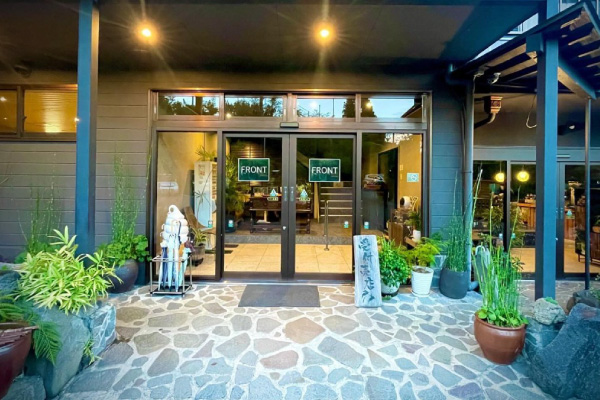 緑に囲まれたエントランスが印象的な温泉施設の正面玄関