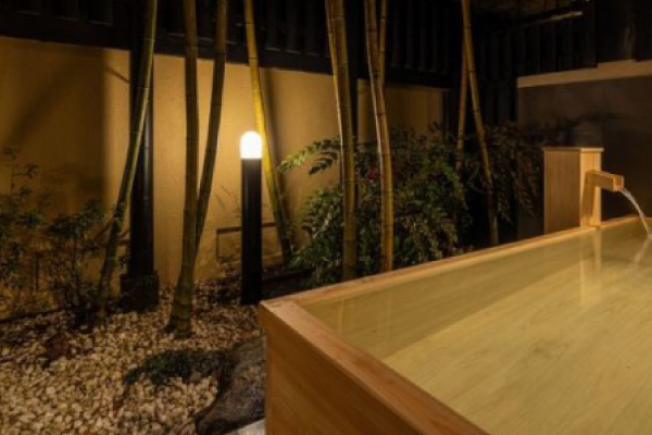 竹林に囲まれた夜の貸切風呂。間接照明が灯る静かな和空間